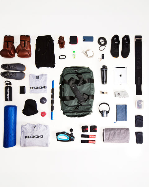 Flat lay of items that can fit inside the KNKG large charcoal PLUS Duffel