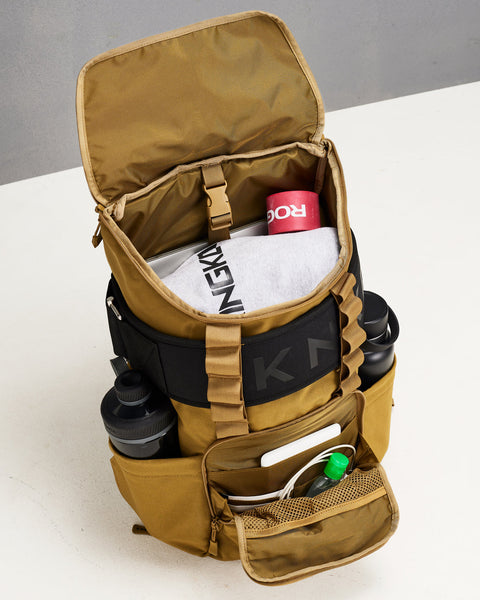 Internal view of desert KNKG CORE Backpack packed with lifting belt, bottles, laptop and gym gear
