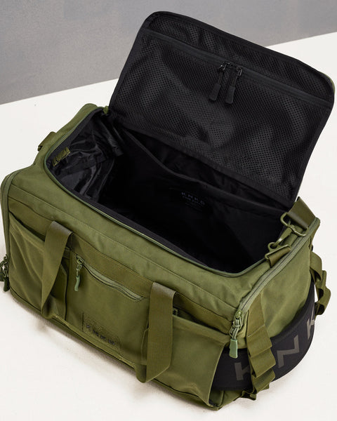 Birds eye view of empty green CORE Duffel, showing internal pockets and laptop sleeve