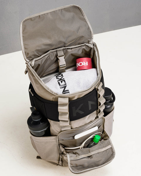 Beige neutral CORE Backpack internal pockets and compartments packed with lifting belt, bottles, laptop and workout accessories such as resistance bands