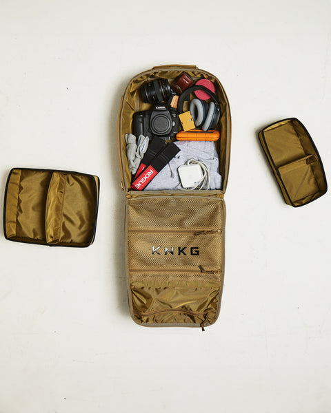 Bird eye view of small desert KNKG CONQUER Backpack packed with camera and gym gear