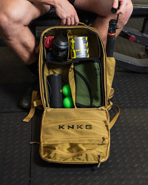 Small desert KNKG CONQUER Backpack with internal divider organization open and packed inside gym