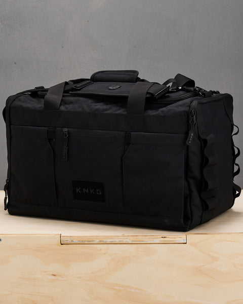 Black CORE Duffel sitting on wooden box