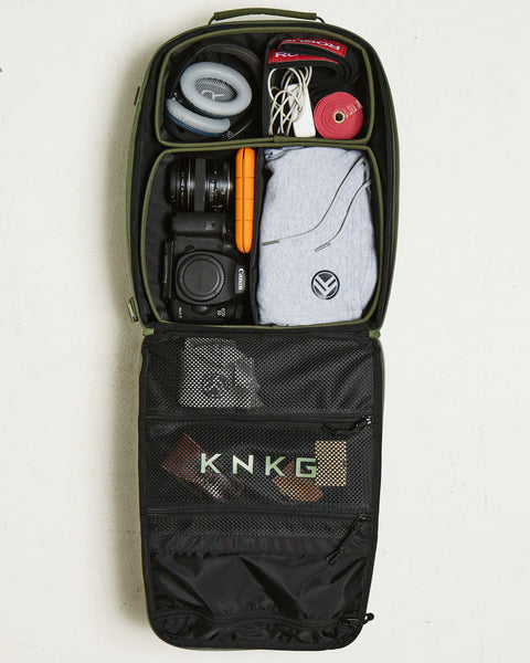 Birds eye view of small green KNKG CONQUER Backpack internal dividers packed with gym essentials