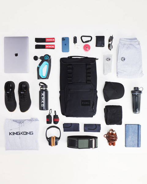Flat lay of items that fit inside of large black CORE Backpack