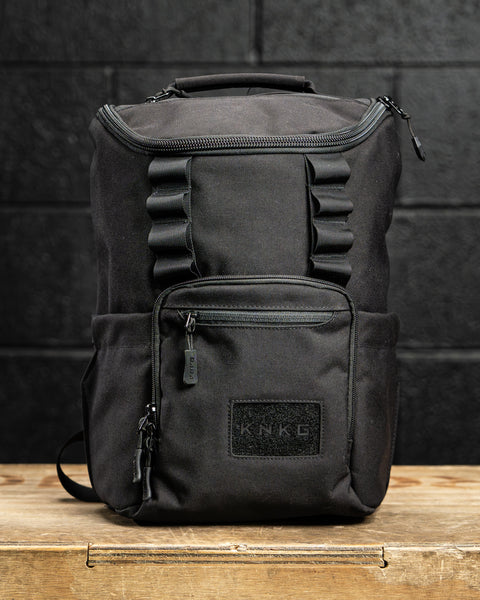 KNKG Mini CORE Backpack in Black sitting on wooden box inside gym