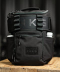 KNKG Mini CORE Backpack in Black sitting on box with matching weightlifting belt 
