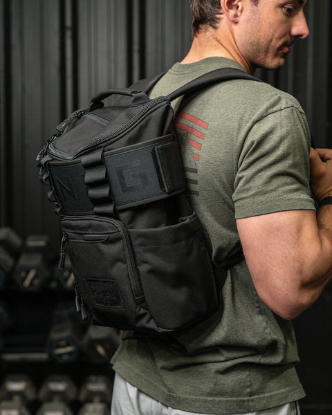 Athlete wearing KNKG Mini CORE Backpack in Black with lifting belt wrapped around bag