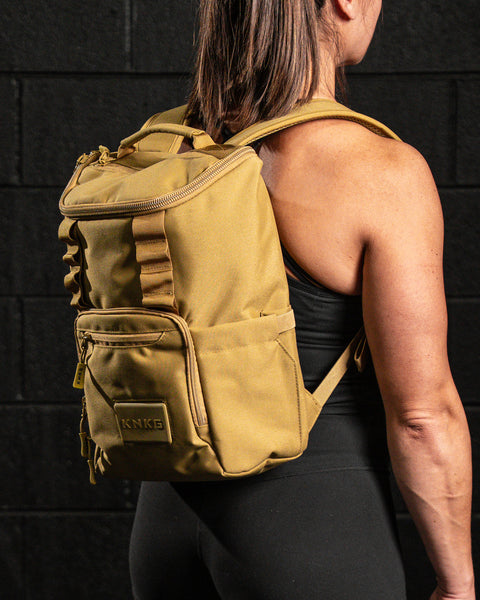 athlete wearing KNKG CORE Mini Backpack in Tan Desert color