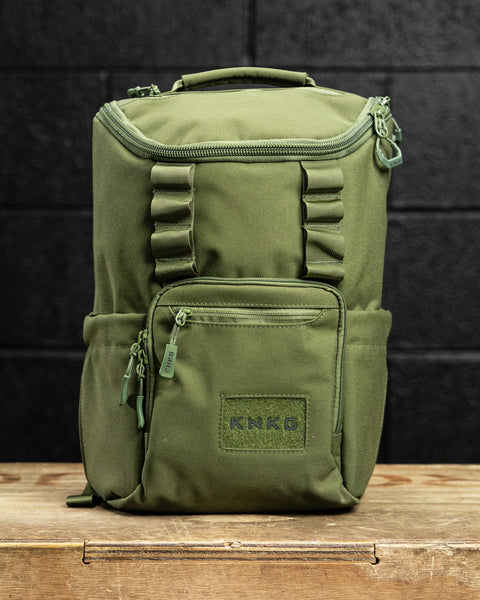 green mini size KNKG CORE Backpack sitting on wooden surface