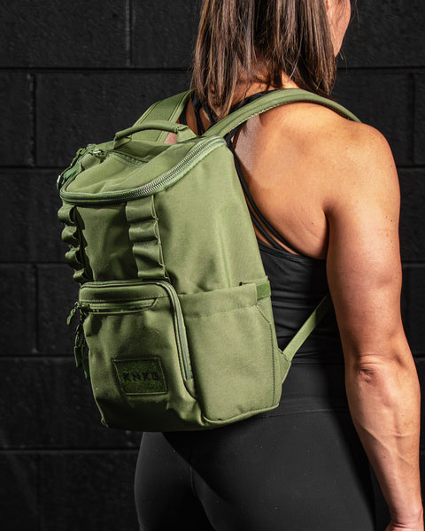 Female athlete wearing green mini size KNKG CORE Backpack 