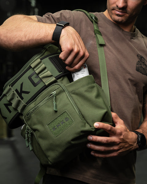 Athlete reaching for pre-workout drink in green mini size KNKG CORE Backpack side pocket