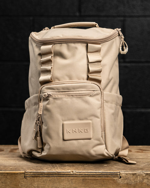 Neutral beige mini size KNKG CORE Backpack on wooden box inside gym