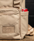 Close up of logo and bottle pocket on Neutral beige mini size KNKG CORE Backpack 