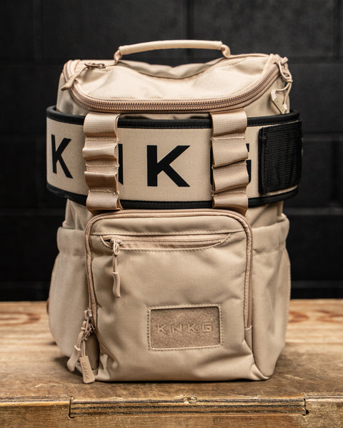 Neutral beige mini size KNKG CORE Backpack on wooden box with lifting belt attached