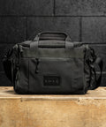 KNKG mini black CORE Duffel sitting on wooden box in gym