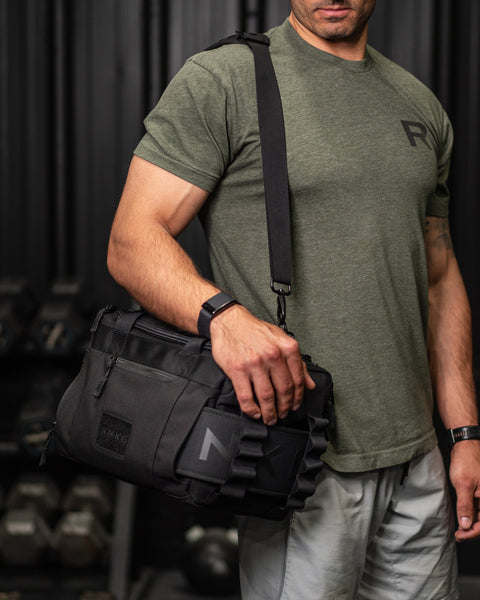 Man wearing KNKG mini black CORE Duffel  over his shoulder