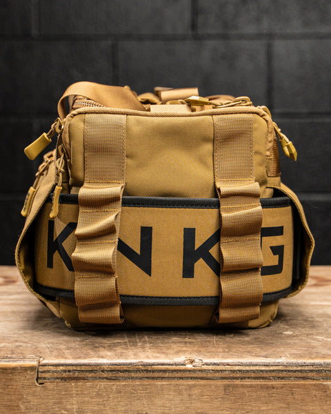 Close up of weightlifting belt packed in sleeve inside KNKG desert tan color mini CORE duffel