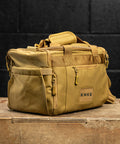 Side view of KNKG desert tan color mini CORE duffel in gym