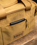 Front pocket of KNKG desert tan color mini CORE duffel with black leather wallet inside