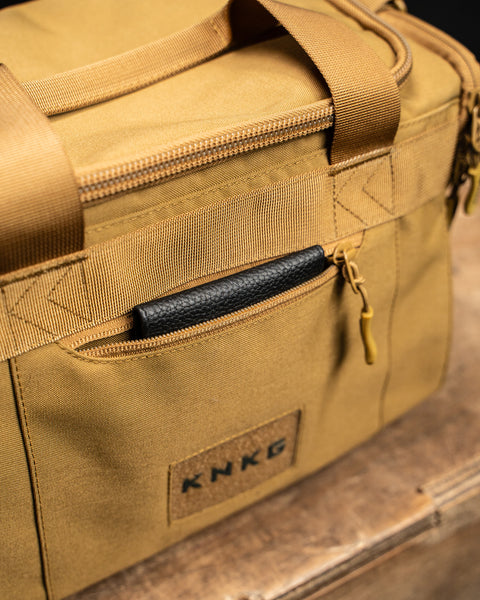 Front pocket of KNKG desert tan color mini CORE duffel with black leather wallet inside