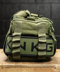 Close up of lifting belt attached to side of green KNKG mini duffel