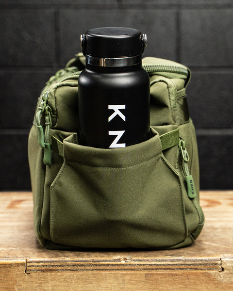 Water bottle inside pocket of green KNKG mini duffel
