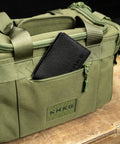 Font pocket of green KNKG mini duffel with wallet inside