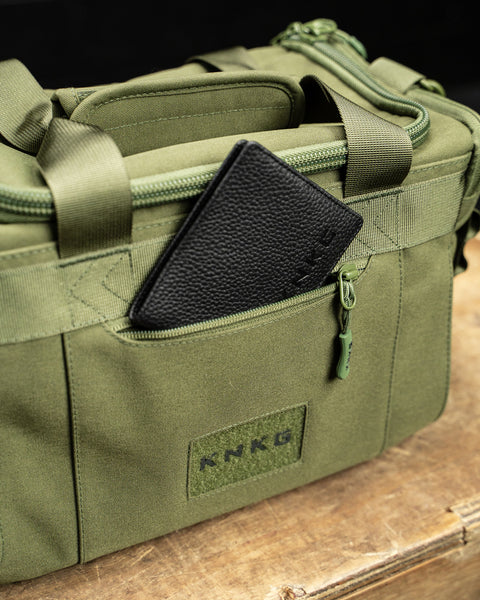 Font pocket of green KNKG mini duffel with wallet inside