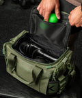Person packing green KNKG mini duffel with mobility accessories 