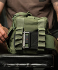 Lifting belt going inside sleeve of side compartment of green KNKG mini duffel