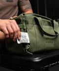 Protein bar in pocket of green KNKG mini duffel