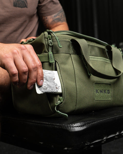 Protein bar in pocket of green KNKG mini duffel