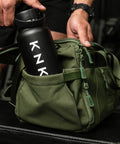 Bottle pocket on side of green KNKG mini duffel