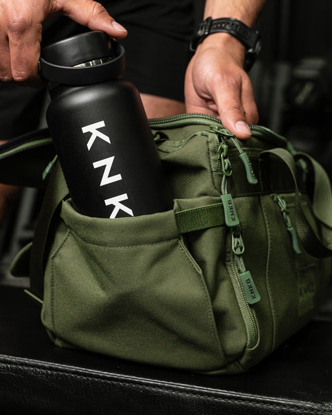 Bottle pocket on side of green KNKG mini duffel
