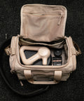 Inside top down view of Neutral beige KNKG mini CORE Duffel with theragun inside