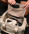 Inside view of Neutral beige KNKG mini CORE Duffel, showing pocket being unzipped 
