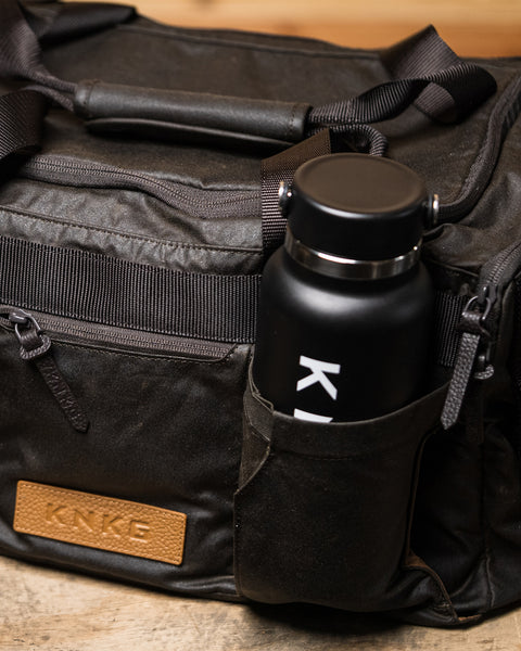 Close up of drink bottle inside pocket of KNKG Waxed Canvas Duffel 