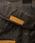Close up of KNKG Waxed Canvas Duffel  with water droplets 