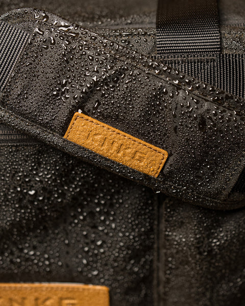 Close up of KNKG Waxed Canvas Duffel  with water droplets 