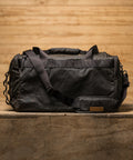 Back view of KNKG Waxed Canvas Duffel sitting on wooden box